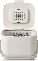 Joseph Joseph stone-colored compost bin with stainless-steel handle and flip-top lid shown on a white background.
