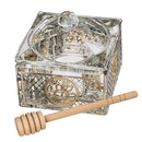 Square crystal honey dish with a decorative metal plaque on a white background.