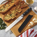 An 8-inch Farberware serrated bread knife with a black handle and protective sheath, resting on a wooden cutting board with sliced garlic bread.