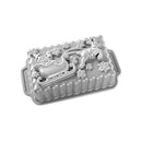 Grey Nordic Ware aluminum loaf pan shaped like Santa's sleigh with reindeer, shown on a white background.
