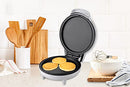 White mini griddle and pizza maker with red and green indicator lights on top, showing its compact size.