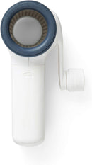 Chef'n spring-loaded rotary grater in white with blue accents, shown with a removable grating drum, designed for easy cheese grating.