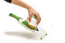Green handheld Farberware mandoline slicer with stainless steel blade on a white background.