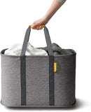 Grey Joseph Joseph collapsible 55L laundry basket with fabric handles, standing upright on a white background.