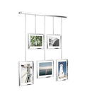 A modern silver photo display featuring five square frames hanging from a horizontal bar by thin rods.
