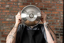 Three round, silver, shiny bowls of varying sizes, arranged from largest to smallest, showing a reflective surface.