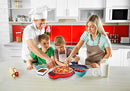 Red electric pizza maker with a cooked pizza inside, lid open, and controls visible.
