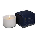 The Trapp No. 77 Palo Santo Small Poured Candle burning, creating a warm and inviting ambiance next to its elegant packaging.