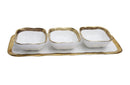 White porcelain relish dish with three square bowls, each featuring an elegant gold trim, placed on a matching rectangular tray.