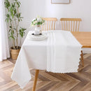 A white lace-patterned tablecloth (70" x 120") draped over a wooden dining table, styled in a modern dining room.