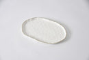 Pampa Bay Portofino medium oval platter with a white hammered texture and gold rim.