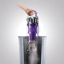 Dust bin being emptied into a trash can.