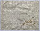 Elegant white challah cover with floral jacquard pattern and gold embroidered Hebrew text in the lower corner