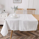 Elegant white 70x144 inch tablecloth with wavy jacquard pattern draped over a large rectangular dining table