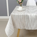 Side view of the 70x108 tablecloth draping over a rectangular table with a cup and saucer set