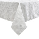White tablecloth with a subtle floral pattern, elegantly draped over a table, showcasing its textured fabric.