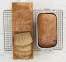 Loaf of bread in the Nordic Ware Procast Classic silver loaf pan  on a white background.