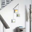 A modern black frame photo display featuring three frames suspended from a horizontal bar by thin rods.