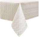 Close-up of a white and gold jacquard tablecloth with a subtle chevron pattern.