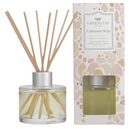 4oz Cashmere Kiss reed diffuser in a clear glass bottle with fiber reeds on a white background.
