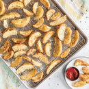 Nordic Ware natural aluminum half sheet pan with oven-safe steel cooling grid, displayed on a countertop