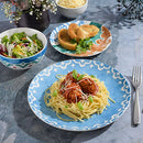 A complete 18-piece porcelain dinnerware set in an off-white color, accented with a warm saffron-toned pattern, from the Spice by Tia Mowry collection.