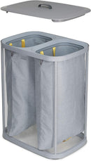 Joseph Joseph Total 90-liter laundry hamper in grey with two removable bags and lid, shown on a white background.