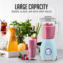 Blue OVENTE blender blending a smoothie beside fresh fruits and a glass of juice on a kitchen counter.