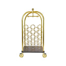 A luxurious, freestanding brass hotel luggage cart repurposed as a wine rack by Godinger, featuring an arched top handle and base, with 23 golden rings forming compartments for wine bottles, all set on a dark, wheeled platform.