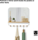 A sleek white wall-mounted organizer mirror with rounded corners, featuring a light wood shelf beneath it. Below the shelf, a white bar extends with several wooden peg hooks.