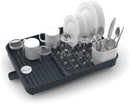 Joseph Joseph gray expandable dish drying rack with cutlery holder and drainboard set on a white background.