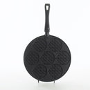Black round waffle pan with seven circular molds, each with a waffle grid pattern, and a black handle.