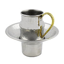 Silver-colored Mayim Achronim (water for the final washing) set, including a cup with a handle and a matching round saucer base. The set has a hammered texture on the cup and base, and the cup features a decorative gold handle.