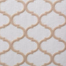 A close-up view of a white, textured shelf liner featuring a raised, repeating taupe quatrefoil pattern.