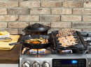 Black cast iron grill pan with raised parallel ridges on the cooking surface and a long handle extending to the right.