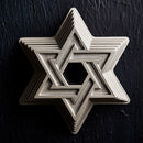 Silver-toned metal baking mold in the shape of the Star of David with central opening.