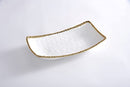 A Pampa Bay Golden Salerno rectangular deep server is shown on a white surface. The dish is white with a subtle hammered or textured appearance and is outlined by a delicate golden beaded rim. The shape is elongated and slightly curved.