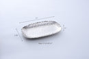 A Pampa Bay Millennium Titanium-Plated Porcelain 11-inch Platter is displayed on a white background. The silver-colored platter features a textured, hammered finish and slightly raised, irregular edges. 