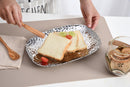 A Pampa Bay Millennium Titanium-Plated Porcelain 11-inch Platter is displayed on a white background. The silver-colored platter features a textured, hammered finish and slightly raised, irregular edges. 
