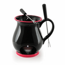 A black ceramic chocolate fondue mug with red trim, two fondue forks, and a tea light holder on a white background