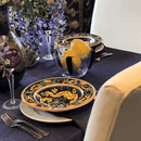 The purple tablecloth draped over a long dining table set for a candlelit dinner with wine glasses and floral centerpieces.