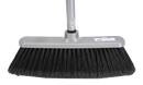 Heavy-duty push broom with black synthetic bristles and a silver handle, ideal for indoor and outdoor sweeping on smooth or rough surfaces.
