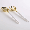 White and gold plastic serving fork and spoon set displayed on a white background.