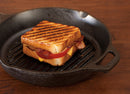A durable 10-inch round cast iron grill pan with raised ridges for perfect grilling indoors. Pre-seasoned for a natural, non-stick surface and even heat distribution. Features a sturdy handle and side spout for easy pouring. Ideal for searing meats, grilling vegetables, and achieving restaurant-quality results at home.