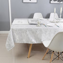The white jacquard tablecloth spread across a large dining table set