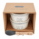 Mud Pie Salsa & Guac Set in a gift box, featuring two white ceramic bowls with black stripes and the words "GUAC" and "SALSA," and a silicone and wood spoon labeled "YUM."