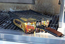 Yukon Glory Premium Grilling Basket, a rectangular wire mesh basket with a long brown handle, and a separate flat wire grill rack.