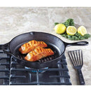 Black cast iron grill pan with raised parallel ridges on the cooking surface and a long handle extending to the right.